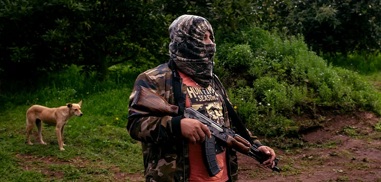 A member of Pueblos Unidos guards an avocado orchard.