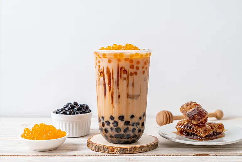 a container of bubble tea with some natural honey